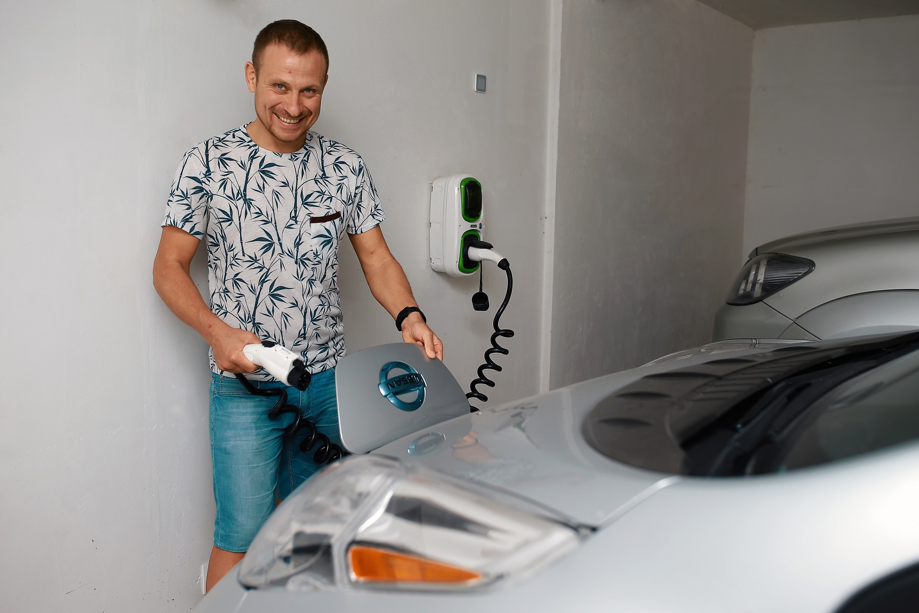 Maxim Ciumaş, entuziasmat de mașina sa personală, pe care o alimentează chiar de acasă, cu energie electrică de la o priză specială. Foto: agora.md